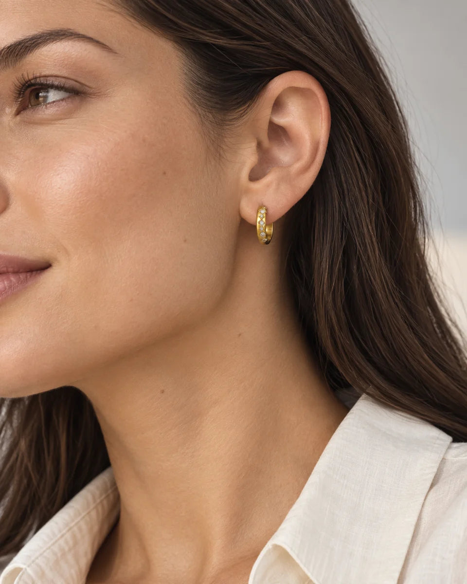 Gold titanium zirconia hoop earrings worn on the ear